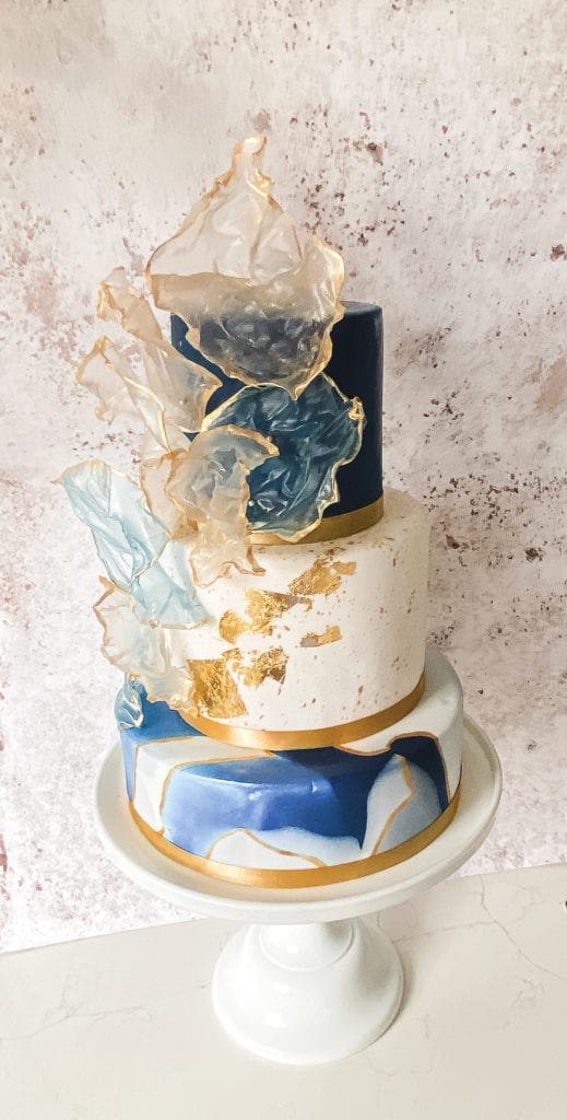 Luxury wedding cake with sugar flowers by Layers and Graces bespoke wedding cakes Hertfordshire Essex London. Blue white gold sugar tiered cake